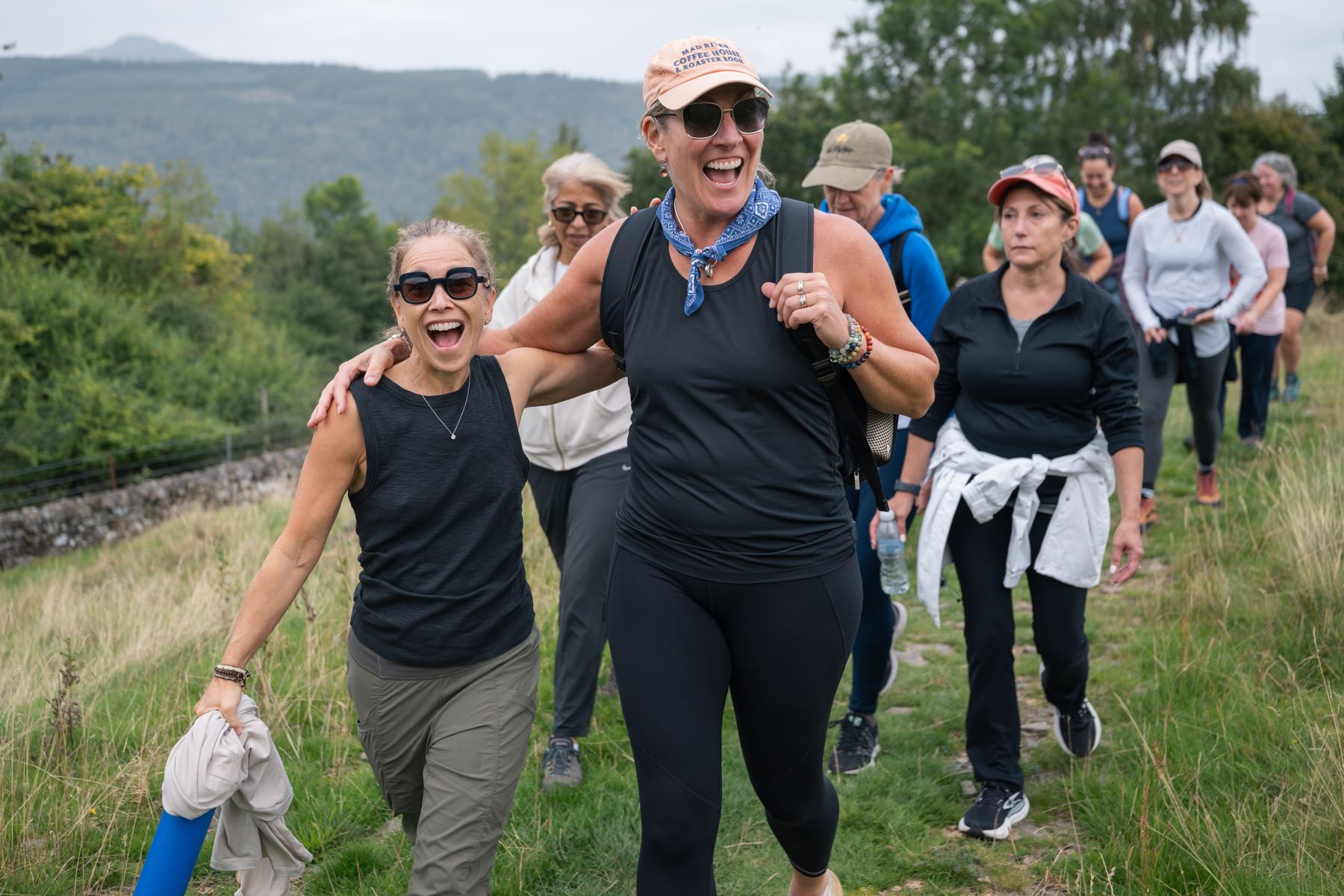 Guests laughing together on a hill walk above the Tay valley